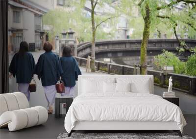 Japanese woman family wearing kimono and walking at Kinosaki Onsen village street in Toyooka City, Hyogo, Japan. See from back side in morning. Japan traveler trip. Wall mural