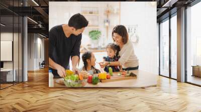 Young Asian love family are preparing the breakfast, sandwich vegetable on table in the kitchen which Excited smiling and felling happy. parent teach daughter to cooking food on the day at home. Wall mural