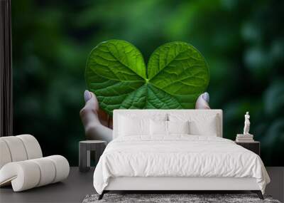 Two Hands Tenderly Cradle a Vibrant Green Leaf, Celebrating the Beauty and Vitality of the Natural World Wall mural