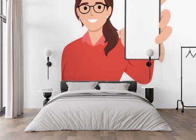 Cheerful beautiful young woman raised her hand to show blank screen in mobile phone while standing. Flat vector illustration isolated on white background Wall mural