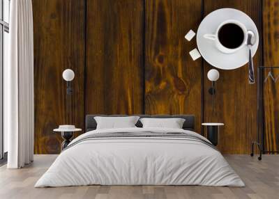 Black coffee with 2 sugars, white cup on a brown wooden table. Top view Wall mural