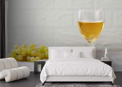 Glass of wine and grapes in the basket on a wooden table. Wall mural