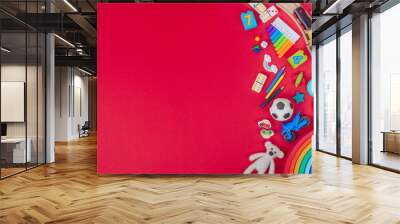 Kids plastic and wooden toys on red background Wall mural