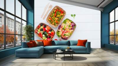 Vegetable salad in the brown kraft paper food containers on white wooden background Wall mural