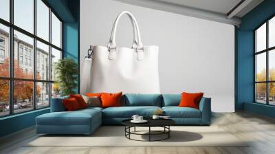 White leather tote bag with a shoulder strap on a white background. Wall mural