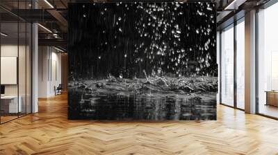 Raindrops falling on a stream, with a black background, evoke a sense of loneliness and pain. Wall mural