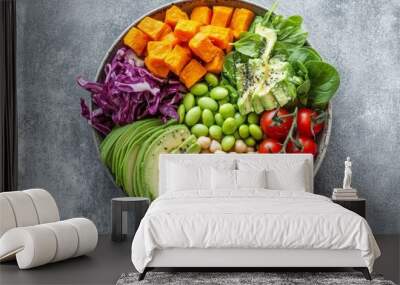 A vibrant bowl of fresh vegetables, avocado, and sweet potato with chickpeas for an eco-friendly meal on a gray background. The photo showcases the colorful arrangement of organic ingredients  Wall mural