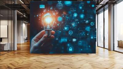 Hand holding light bulb with digital icons and network connection on blue background, representing innovation in technology for business or education. High quality, professional photography Wall mural