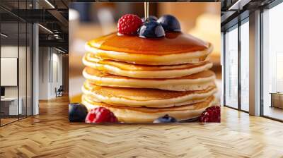 Indulge in the sight of fluffy pancakes stacked high, drizzled with golden maple syrup, and topped with fresh berries and a pat of melting butter  Wall mural