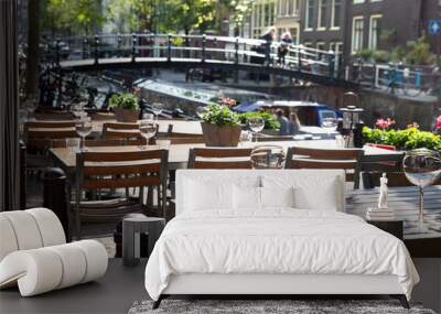 Amsterdam restaurant cafe tables set for outdoor dining with glassware and view of canal bridge in the background Wall mural