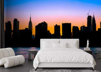 New York City skyline with silhouetted buildings and colorful sunset sky  Wall mural