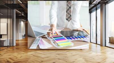 graphic designer using color swatch to do his work at modern office. architect using work tools and  Wall mural