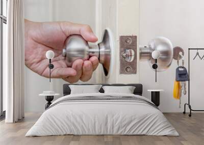 Hand holding door knob with keys Wall mural