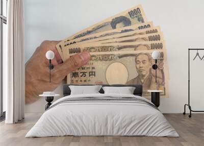 Hand holding Japanese Yen banknote on white background Wall mural