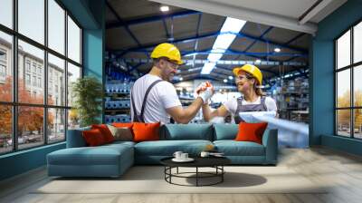 Factory workers handshaking each other at production line. Wall mural