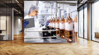 Female factory expert controlling wine production in alcohol beverage bottling plant. Wall mural