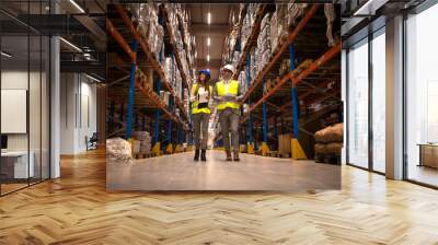 Managers walking through large warehouse controlling goods distribution. Wall mural