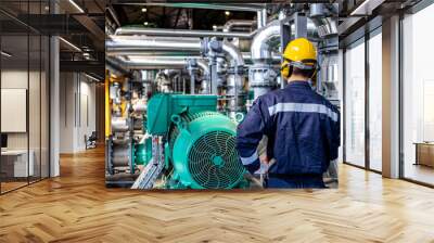 Refinery worker standing by gas fuel engines inside power plant checking production of electricity. Wall mural