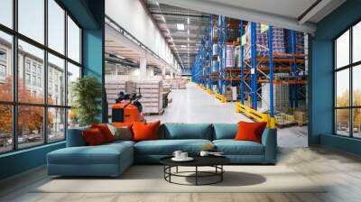 Warehouse storage facility interior. Large distribution center with shelves full of palette boxes and forklift machine. Wall mural