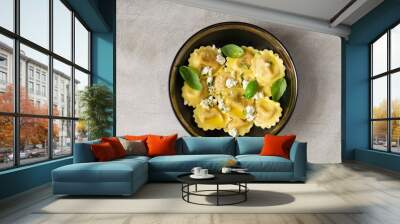 Girasoli pasta with soft cheese, olive oil and basil leaves in black bowl isolated on grey background. Italian, Mediterranean lunch or dinner.  Top view.  Wall mural