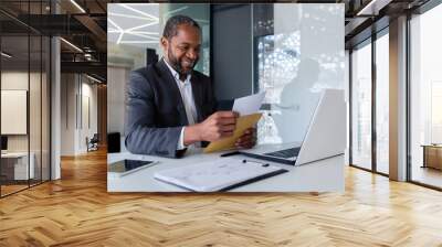 African american businessman reading good news, man inside office workplace holding mail envelope letter with good news, boss in business suit mature and adult. Wall mural