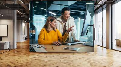 business team man and woman, working together, happy and cheerful, looking at a computer monitor, co Wall mural