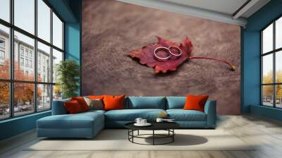 Close-up photo of wedding rings with autumn leaves Wall mural