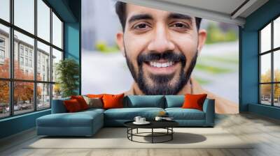 Close up photo portrait of young Hindu student, man smiling and looking at camera, businessman outside office building wearing shirt. Wall mural