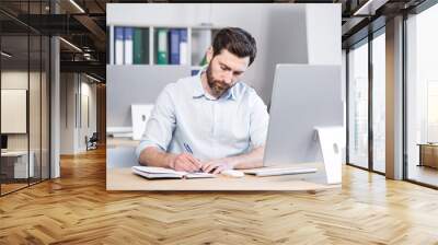 Confident business man stocks broker sitting in front of monitor screen in office analyzing stat of index charts data analyses market trend. Forex trading agency worker agent reviewing profits growth Wall mural