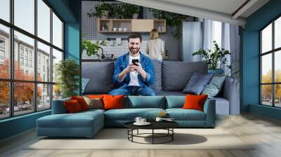 man has a secret communication correspondence with his mistress, sitting on the couch at home Wall mural