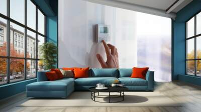 The air conditioning and heating control panel for the apartment and office is located on a white wall Wall mural