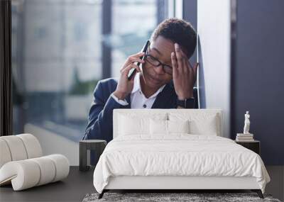 Woman businessman sad complains on the phone, reports bad news, African American woman in despair near the office, holding hands behind his head Wall mural