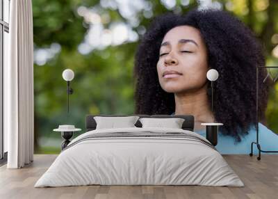 Woman embracing mindfulness in tranquil outdoor environment, eyes closed in peaceful meditation. Connection with nature promotes relaxation and inner peace, enhancing mental well-being Wall mural