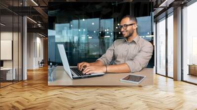 young successful indian programmer working inside modern development company, man using laptop to wr Wall mural