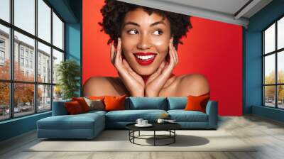 Beautiful smiling african american woman with red lips, glowing naked body wrapped in red ribbon, concept of skin care, winter holidays and Christmas gifts Wall mural