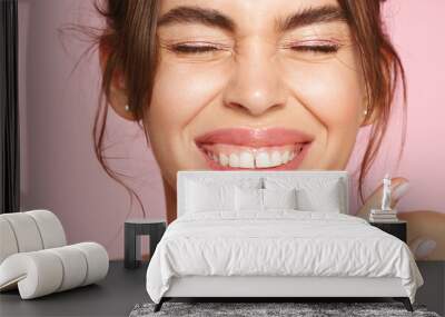 Close up of happy young woman with fresh glowing skin tone, showing beautiful white smile and grinning carefree, happy about valentines day, standing on pink background Wall mural