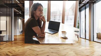 Good-looking successful ambitious female entrepreneur sit cafe co-working space turn aside smiling pleased laughing talking coworkers prepare project sit near laptop piles books drink coffee Wall mural