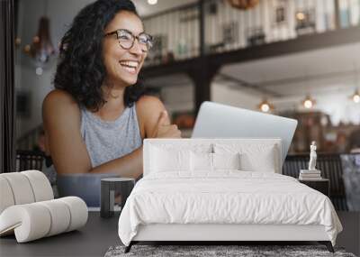 Side-shot enthusiastic happy carefree female student prepare freelance project working laptop sitting cafe laughing joyfully contemplate outside window wear glasses enjoy cappuccino Wall mural