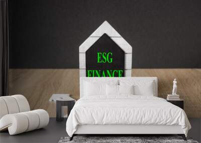 Concept words EGS FINANCE on black blackboard. Beautiful wooden table, black background. A stack of coins. Finance concept business succeed. Wall mural