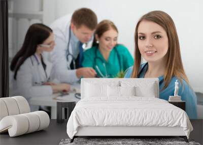 Portrait of smiling female medicine doctor holding folder with d Wall mural