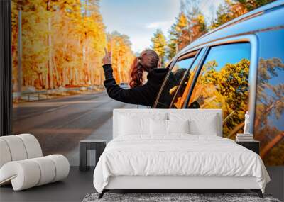 Pretty young brunette woman travelling by car late autumn on the mountains road Wall mural