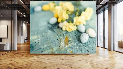 Yellow beautiful flowers and blue and yellow colored easter eggs on a blue picturesque oil painting background close up. Mockups. Layout. Spring pastel background. Easter pastel contemporary backgroun Wall mural