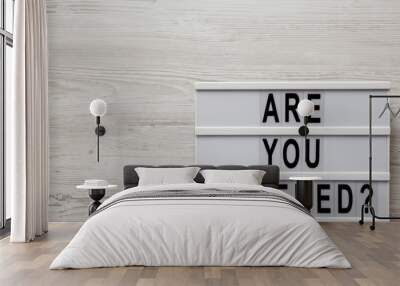 'Are you covered?' words on a modern board on a white wooden background, top view. Overhead, from above, flat lay. Space for text. Wall mural