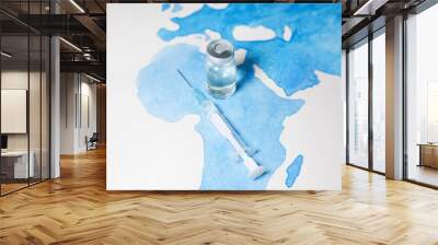 Bottle of coronavirus vaccine and syringe on world map background. Science laboratory research, vaccination concept. Coronavirus outbreak situation. Wall mural