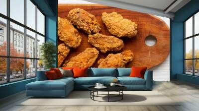 Chicken wings on a wooden board with red pepper sauce on white wooden background, overhead view. Close-up. Wall mural