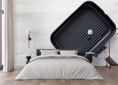 Empty grill pan on a white wooden background, top view. Overhead, from above, flat lay. Copy space. Wall mural