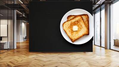 Homemade Buttered Toast on a white plate on a black background, top view. Flat lay, overhead, from above. Copy space. Wall mural