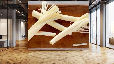 String cheese on rustic wooden board over white wooden surface, top view. Healthy snack. Flat lay, overhead, from above. Wall mural