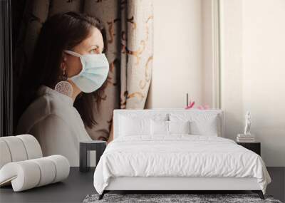 Woman in medical mask stay isolation at home for self quarantine. Concept home quarantine, prevention COVID-19, Coronavirus outbreak situation, post covid syndrome. Copy space for your text. Wall mural