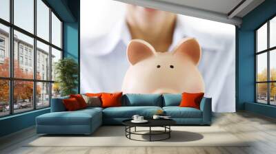 smiling female holding piggy-bank Wall mural